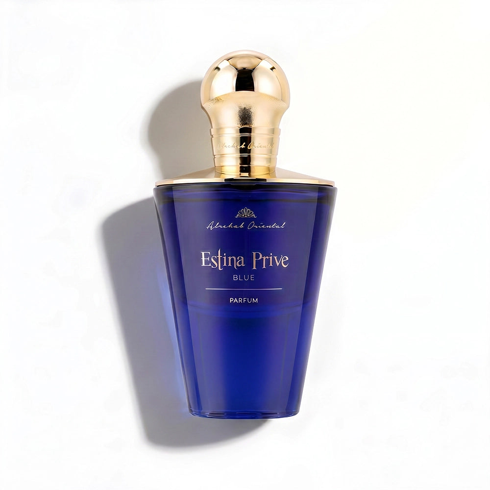 A bottle of Michael Oriental Estina Prive Blue Parfum, featuring a deep cobalt blue glass body and a metallic gold spherical cap, set against a plain white background with a soft shadow.